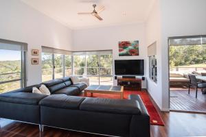 a living room with a black leather couch and a flat screen tv at Cantley at Flutes Estate, Margaret River in Wilyabrup