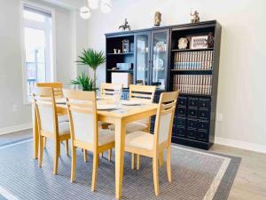 uma sala de jantar com uma mesa de madeira e cadeiras em Luxurious Executive Style Townshouse with parking em East Gwillimbury