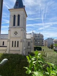 eine Kirche mit einem Turm mit einer Uhr drauf in der Unterkunft Appartement cozy pour 4 personnes - A 5 minutes de Paris in Levallois-Perret