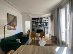 sala de estar con sofá verde y mesa en Appartement cozy pour 4 personnes - A 5 minutes de Paris, en Levallois-Perret