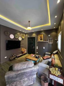 ein Wohnzimmer mit 2 Sofas und einem TV in der Unterkunft Stylish Apartment with garden in Kairo