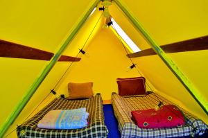 a room with two beds in a tent at Mundo Abu San Juan La laguna in San Juan La Laguna