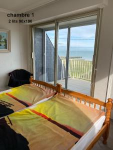a bedroom with a bed with a view of the ocean at gavres-port-louis-ocean in Gâvres