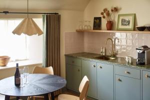 a kitchen with a table and a sink and a counter at Dawn at The Sun Inn Felmersham, Our Signature Duplex Suite in Sharnbrook