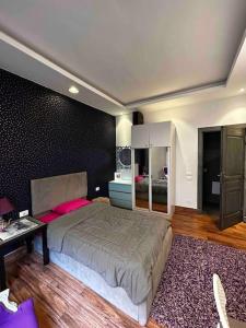 ein Schlafzimmer mit einem großen Bett und einem Schreibtisch in der Unterkunft Stylish Apartment with garden in Kairo