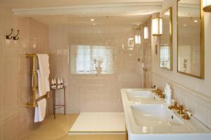 een witte badkamer met een wastafel en een douche bij Dawn at The Sun Inn Felmersham, Our Signature Duplex Suite in Sharnbrook