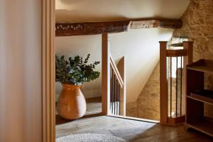 a hallway with a vase with a plant in it at Dawn at The Sun Inn Felmersham, Our Signature Duplex Suite in Sharnbrook