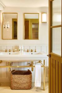 een badkamer met een witte wastafel en 2 spiegels bij Dawn at The Sun Inn Felmersham, Our Signature Duplex Suite in Sharnbrook