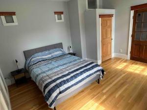 a bedroom with a bed and a wooden floor at Spacious Medford Gem in Medford