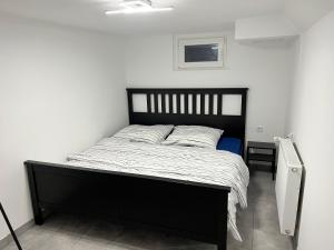 1 dormitorio con cama negra y edredón blanco en Nice Calm Souterrain Appertment in Ratingen en Ratingen