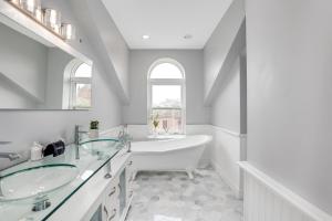 a bathroom with two sinks and a bath tub at The Lumber Baron's Mansion: 2 King Suites, 2.5BA + Gym in Detroit +140 photos