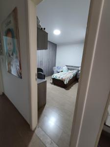 um corredor para um quarto com uma cama num quarto em Suíte privativa em casa de família em São Paulo