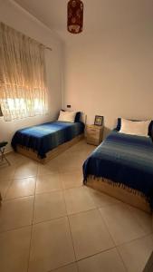 - une chambre avec 2 lits et une fenêtre dans l'établissement APPARTEMENT COSY Au PALMERAIE VILLAGE - 5 PISCINES, à Marrakech