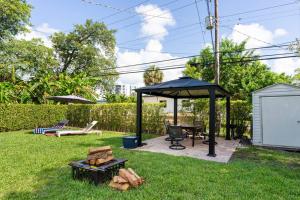a gazebo in a yard with a table and a grill at Cozy Place in Miami