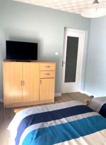 ein Schlafzimmer mit einem Bett und einem TV auf einem Schrank in der Unterkunft Maison au calme, 6 voyageurs in Riorges