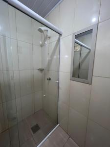 y baño con ducha y puerta de cristal. en Casa privativa completa e aconchegante! en São José