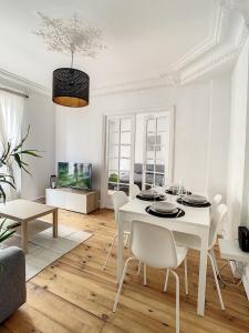 a white dining room with a white table and chairs at Grand Cozy appart - proche métro Paris - spots touristiques in Ivry-sur-Seine