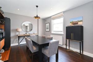 a dining room with a black table and chairs at Large 3 Bedroom Covent Garden Apartment in London