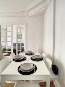 ein weißes Esszimmer mit einem weißen Tisch und Stühlen in der Unterkunft Grand Cozy appart - proche métro Paris - proche spots touristiques in Ivry-sur-Seine