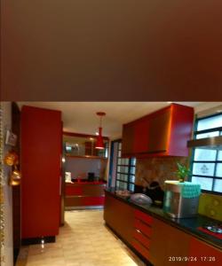 een keuken met rode kasten en een rood aanrecht bij Suite na varanda para casais in Foz do Iguaçu