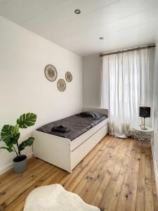 ein weißes Schlafzimmer mit einem Bett und einem Fenster in der Unterkunft Grand Cozy appart - proche métro Paris - proche spots touristiques in Ivry-sur-Seine