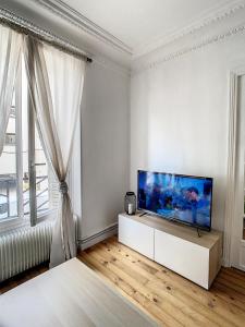 En TV eller et underholdningssystem på Grand Cozy appart - proche métro Paris - proche spots touristiques