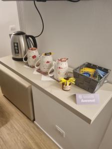 un mostrador con 3 tazas de té y un microondas en LaLunaMia B&B and Holiday Apartment, en Bedollo