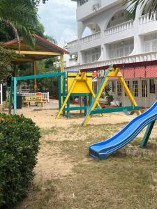 um parque infantil com um escorrega em frente a um edifício em Beachfront Luxe Apt em Runaway Bay