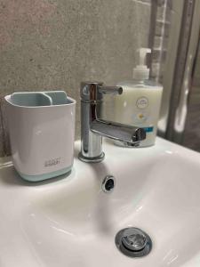 a sink with a toothbrush and a cup on it at Luxury 1 bed Flat + sofa bed- Dudley 