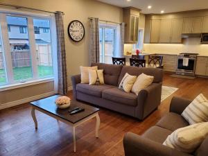 a living room with a couch and a table at 4 BD Family Retreat in Stratford