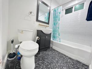 een badkamer met een toilet, een wastafel en een bad bij Little Bettys Cottage in Torrance