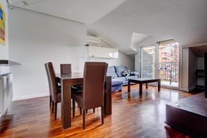 a dining room and living room with a table and chairs at Luminoso ático con terraza, Irún in Irún