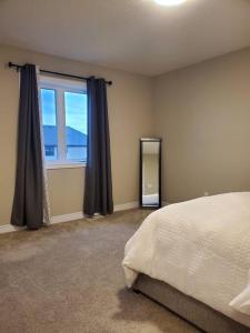 a bedroom with a bed and a large window at 4 BD Family Retreat in Stratford