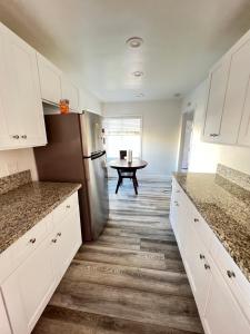 a kitchen with white cabinets and a stainless steel refrigerator at Little Bettys Cottage in Torrance