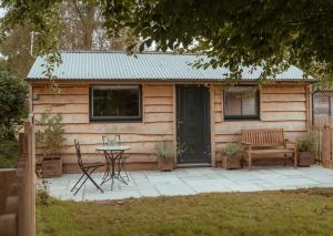 a cabin with a table and chairs in front of it at Rose Hideaway - Forest of Dean Cosy Cabin Retreat in Yorkley
