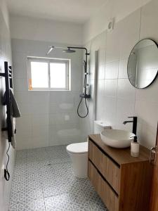 uma casa de banho com um WC, um lavatório e um espelho. em Open and airy home 