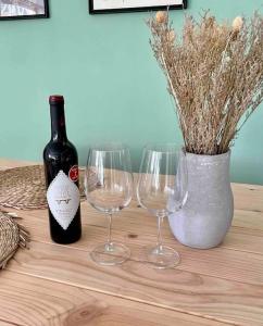 uma mesa com dois copos de vinho e uma garrafa de vinho em Open and airy home 