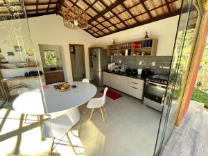 a kitchen with a table and chairs in a room at Refúgio By Bellatrix Ecolodge in Mata de Sao Joao