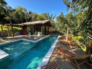 a swimming pool with chairs and a gazebo at Refúgio By Bellatrix Ecolodge in Mata de Sao Joao