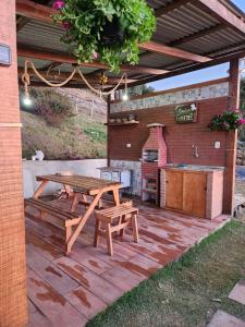 patio ze stołem piknikowym i sprzętem do grillowania w obiekcie Cabana Alpes w mieście São Bento do Sapucaí