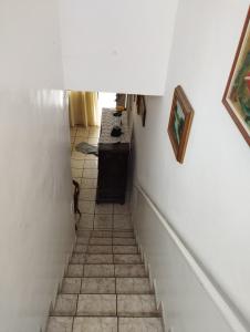 a hallway with white walls and a tile floor at Duplex Encantador in Guarapari