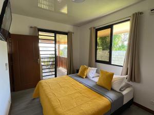 una camera da letto con letto con lenzuola e finestre gialle di Villa Toa Pearl Bora Bora a Bora Bora
