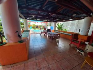 ein Restaurant mit einer Terrasse mit Tischen und Stühlen in der Unterkunft MARDEORO BEACH HOUSE in Barra de Santiago