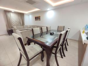 Luxurious Appartment in GOLDCREST DHA Lahore في لاهور: غرفة طعام مع طاولة وكراسي زجاجية