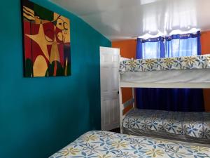1 Schlafzimmer mit 2 Etagenbetten und einem Gemälde an der Wand in der Unterkunft MARDEORO BEACH HOUSE in Barra de Santiago