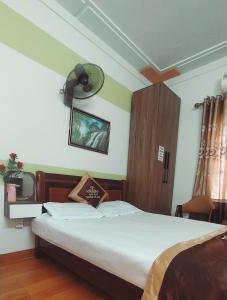 een slaapkamer met een bed en een ventilator aan de muur bij Nhà nghỉ Thiện Trang in Kiến An
