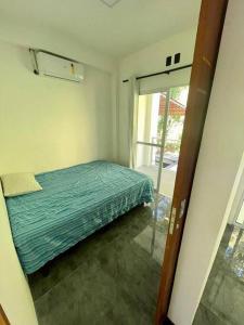 Schlafzimmer mit einem Bett und einer Glasschiebetür in der Unterkunft Casa aconchegante com piscina in Paraty