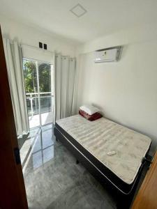 ein Schlafzimmer mit einem Bett in einem Zimmer mit einem Fenster in der Unterkunft Casa aconchegante com piscina in Paraty