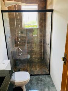 ein Bad mit Dusche, WC und Fenster in der Unterkunft Casa aconchegante com piscina in Paraty