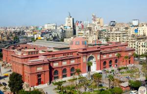 a large red brick building with a city in the background at Elegant room in the city center in Cairo